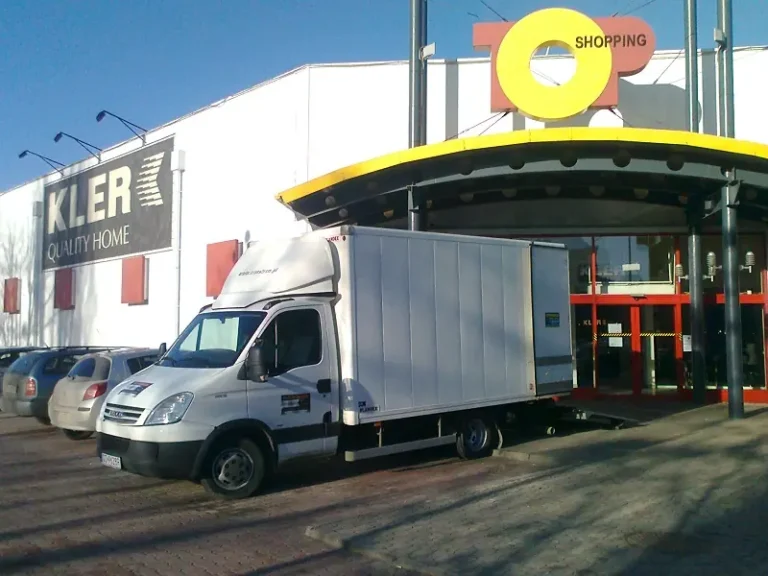 Biała furgonetka przed salonem meblowym - firma transportowa Gdańsk realizująca transport mebli Gdańsk