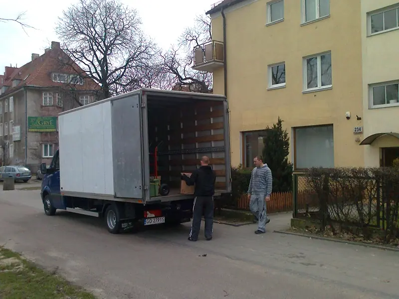 Pracownicy realizujący przeprowadzki mieszkań ładujący kartony - kompleksowe usługi transportowe Gdańsk