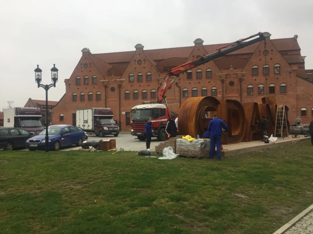 Ciężki transport przewóz towarów rzeczy Gdańsk podczas montażu liter