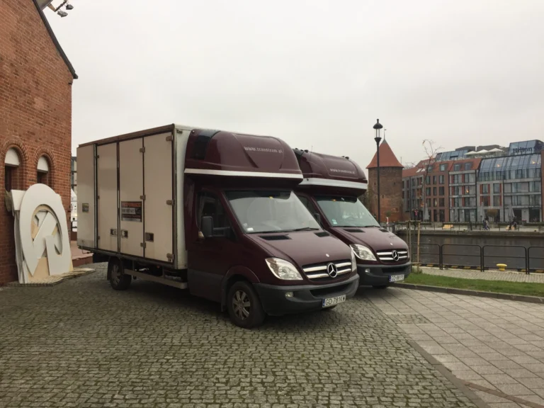 Dwa bus busy towarowe bagażowe zaparkowane nad Motławą, realizujące transport Gdańsk
